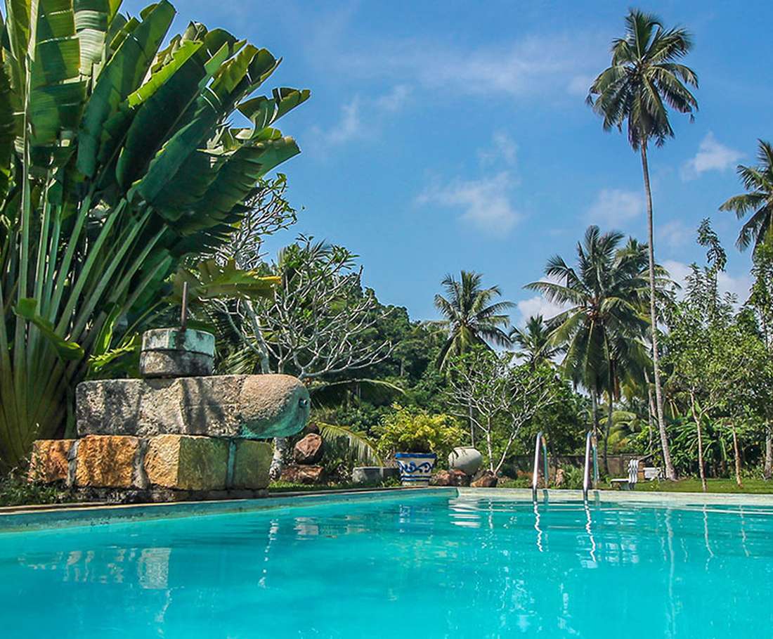 Het turquoise zwembad tussen de palmen bij het koloniale huis in Unawatuna, Sri Lanka
