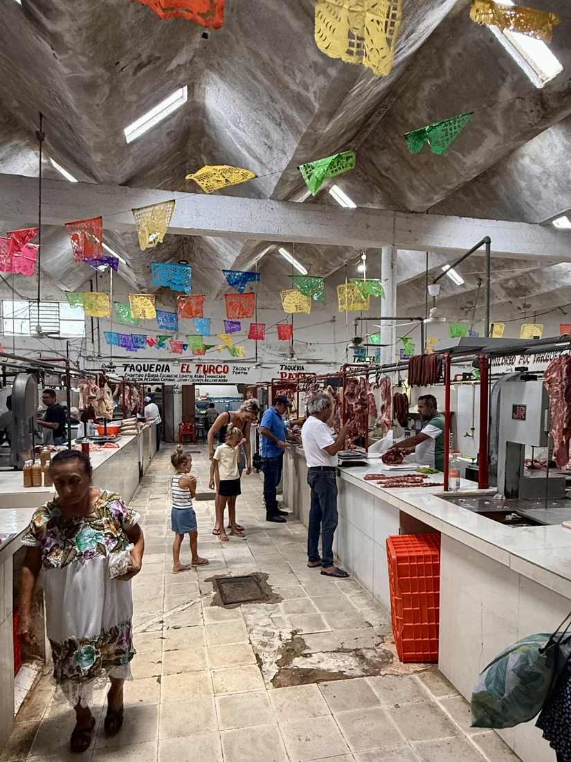 Een markthal met slingers van gekleurd papier aan het plafond