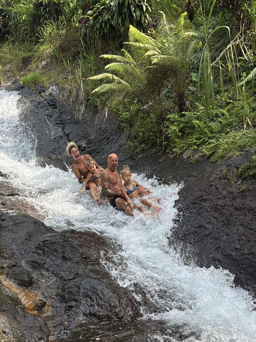 Ilse met haar gezin in het stromende water van een natuurlijke glijbaan