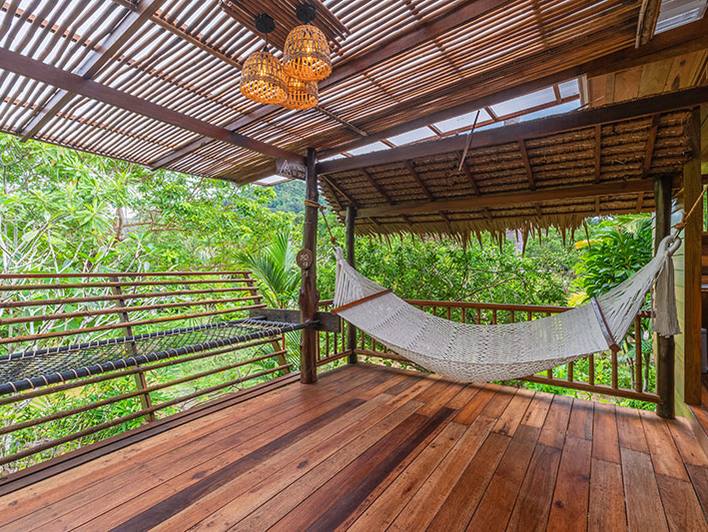 Hangmat op een houten terras tussen het groen bij Ao Nang, Krabi, Zuid-Thailand