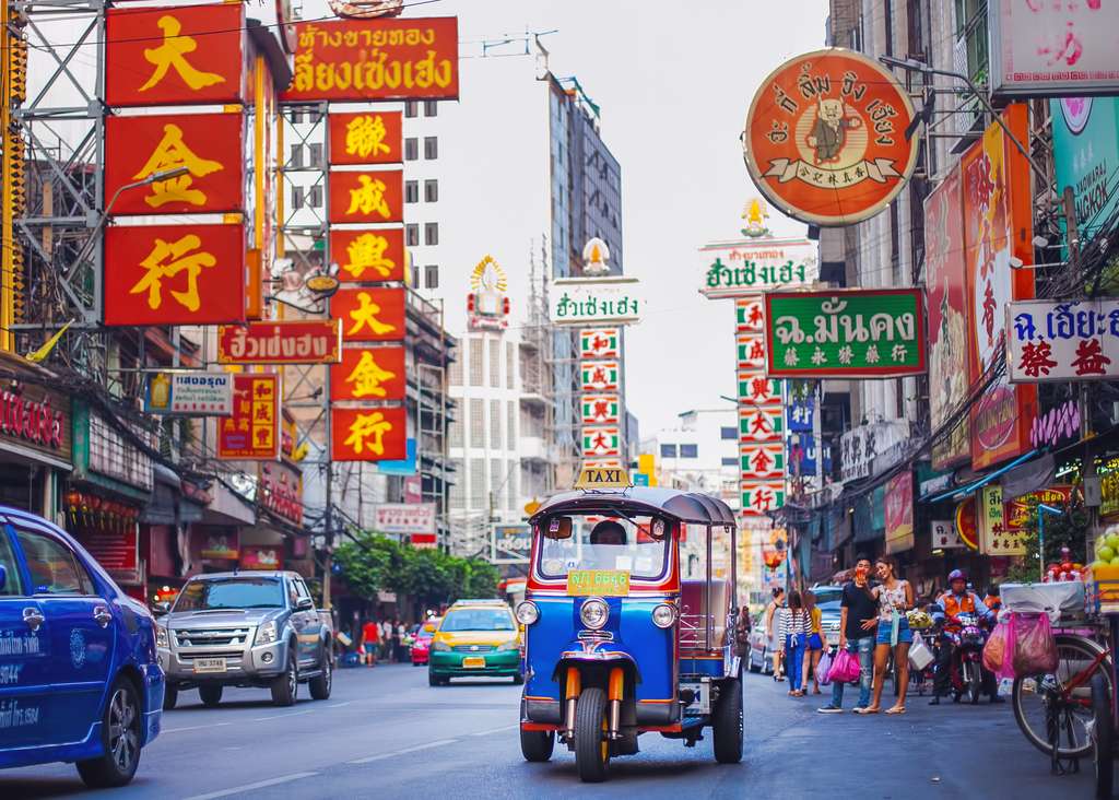 Neonborden en tuktuks in Chinatown in Bangkok, Thailand