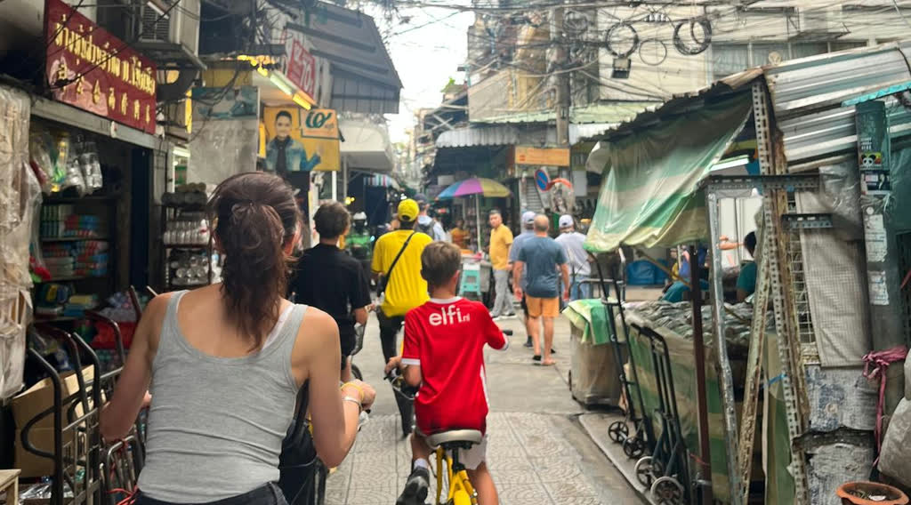 Fietsen door een steegje in Bangkok, Thailand