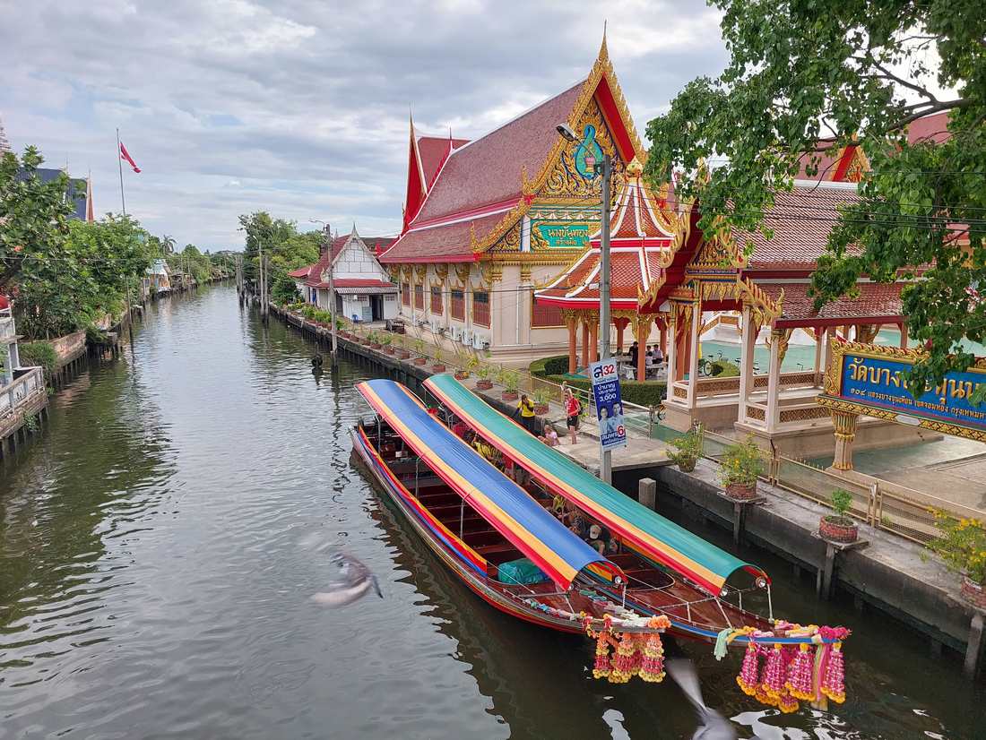 Tempel en longtailboten aan een kanaal in Bangkok, Thailand
