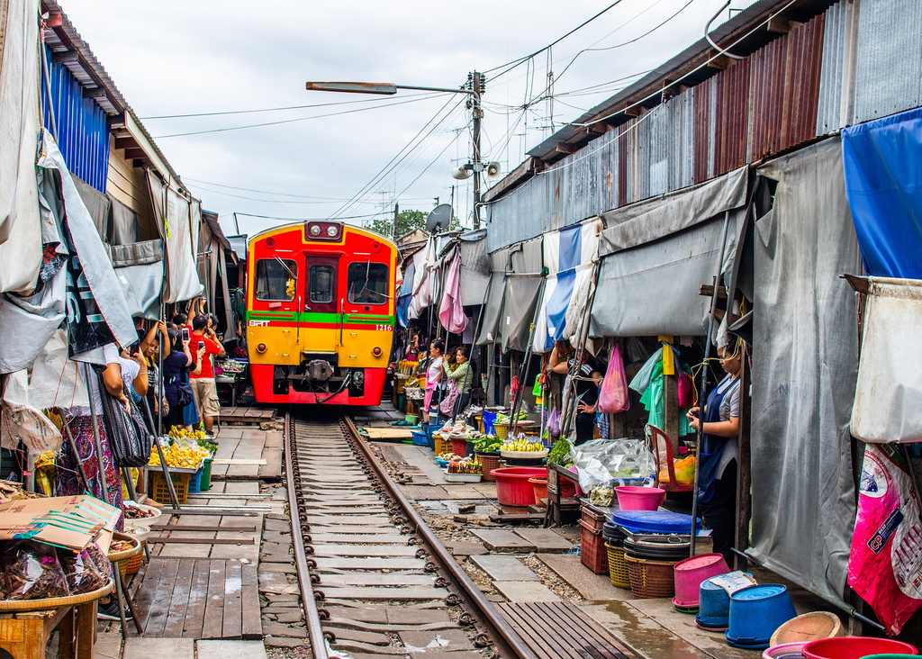 Trein rijdt dwars door de spoormarkt bij Bangkok, Thailand