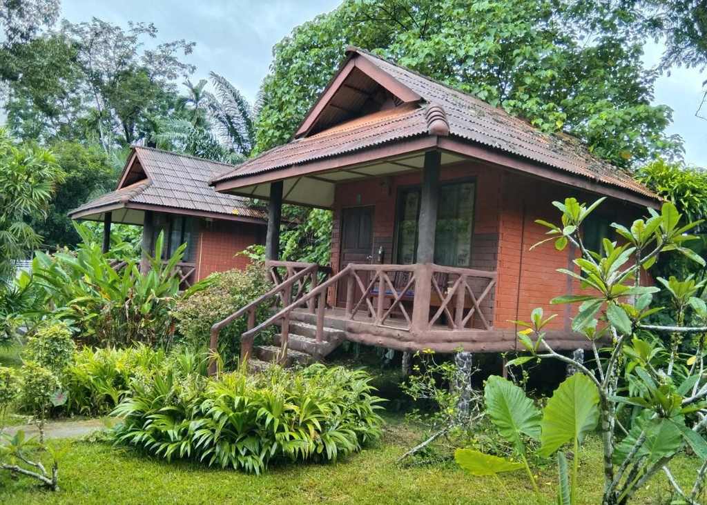 Houten bungalow tussen het groen aan de rivier bij Khao Sok, Zuid-Thailand