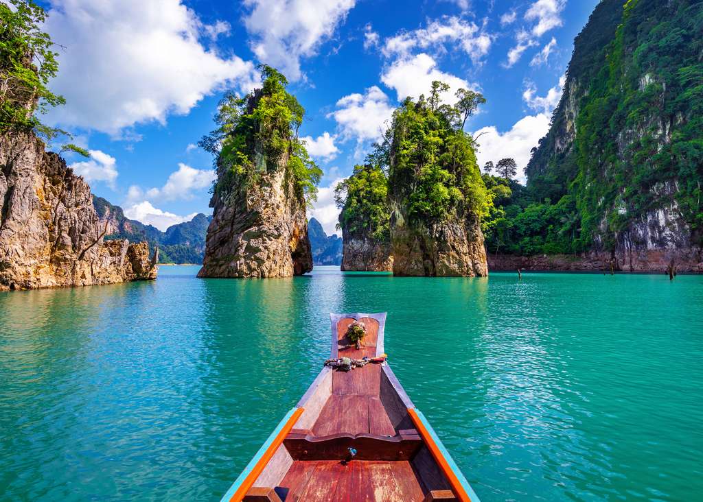 Longtailboot tussen de kalkrotsen op het meer van Khao Sok, Zuid-Thailand