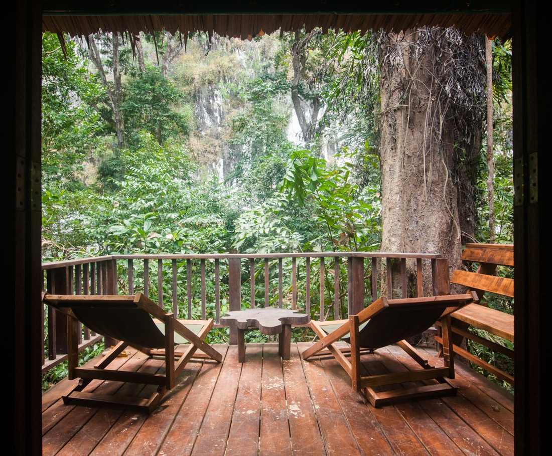 De veranda van een houten huisje met uitzicht op de kalkrotsen bij Khao Sok, Thailand