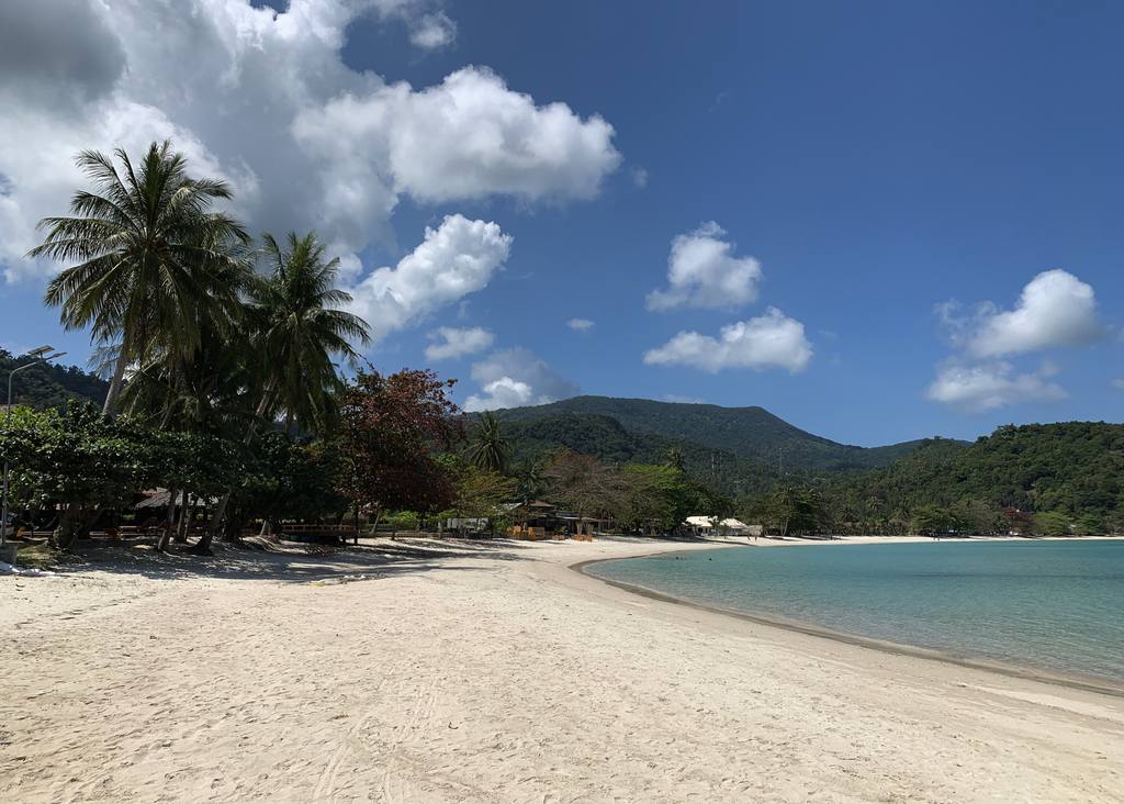 Breed strand met bergen op de achtergrond op Koh Phangan, Thailand