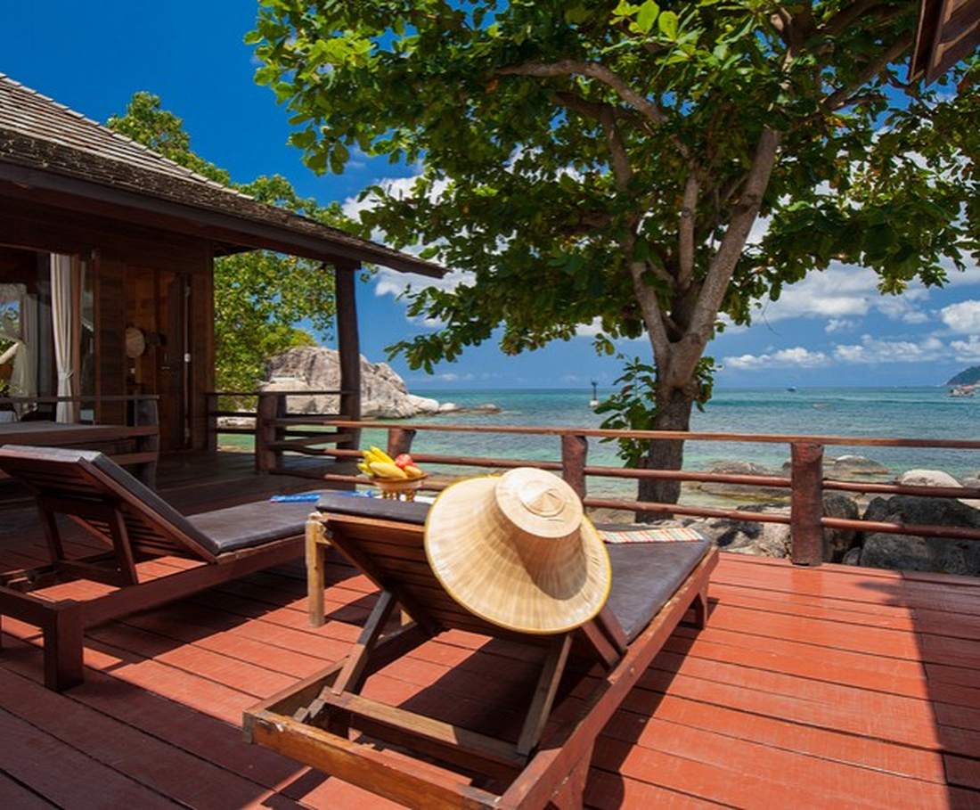 Ligstoelen op een houten terras aan de baai van Koh Tao, Thailand