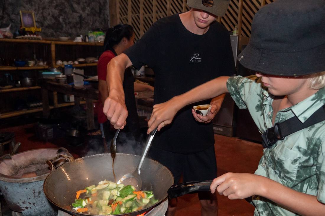 Koken in de wok tijdens een kookworkshop bij Khao Sok, Thailand