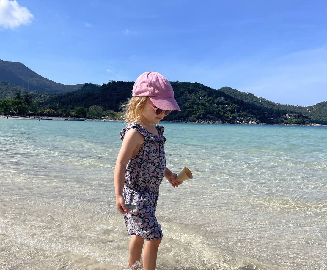Een peuter pootjebaadt in het heldere water bij Koh Tao, Thailand