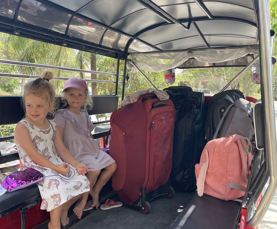 Twee peuters in een tuktuk tussen de koffers in Bangkok, Thailand