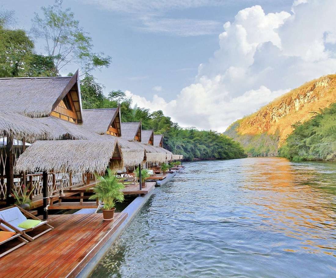 Een rij drijvende villa's met rieten daken aan de rivier de Kwai, Thailand