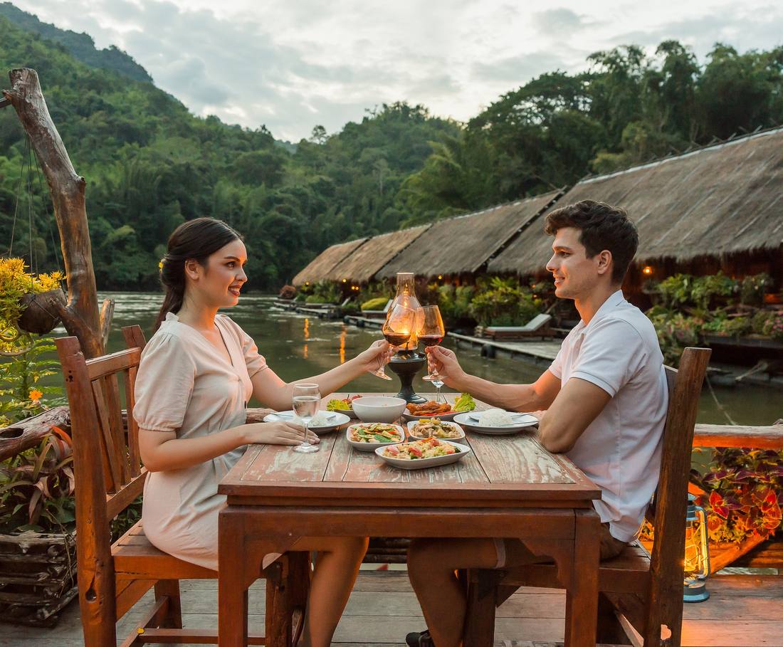 Eten aan een tafel aan de rivier de Kwai, Thailand