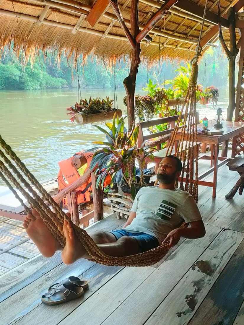 In de hangmat op een vlothuisje aan de rivier de Kwai, Thailand