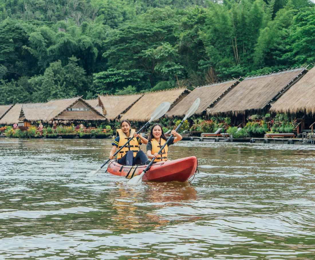 Kajakken langs de drijvende huisjes aan de rivier de Kwai, Thailand