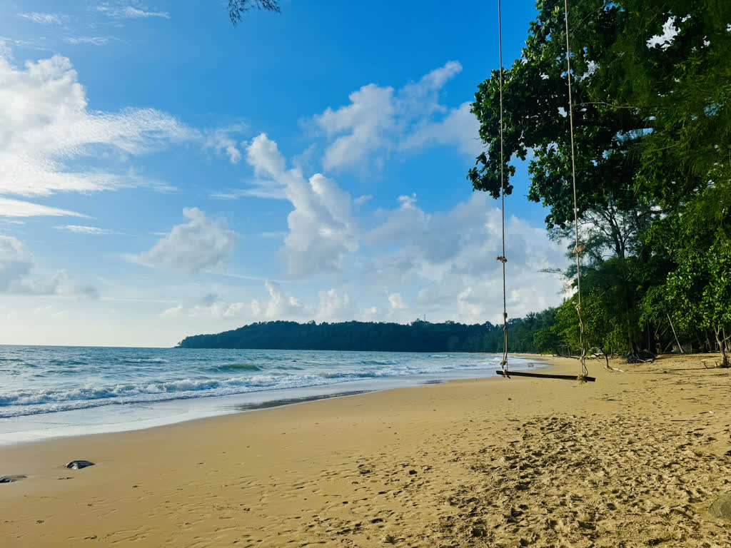 Schommel aan een boom op een leeg strand in Thailand
