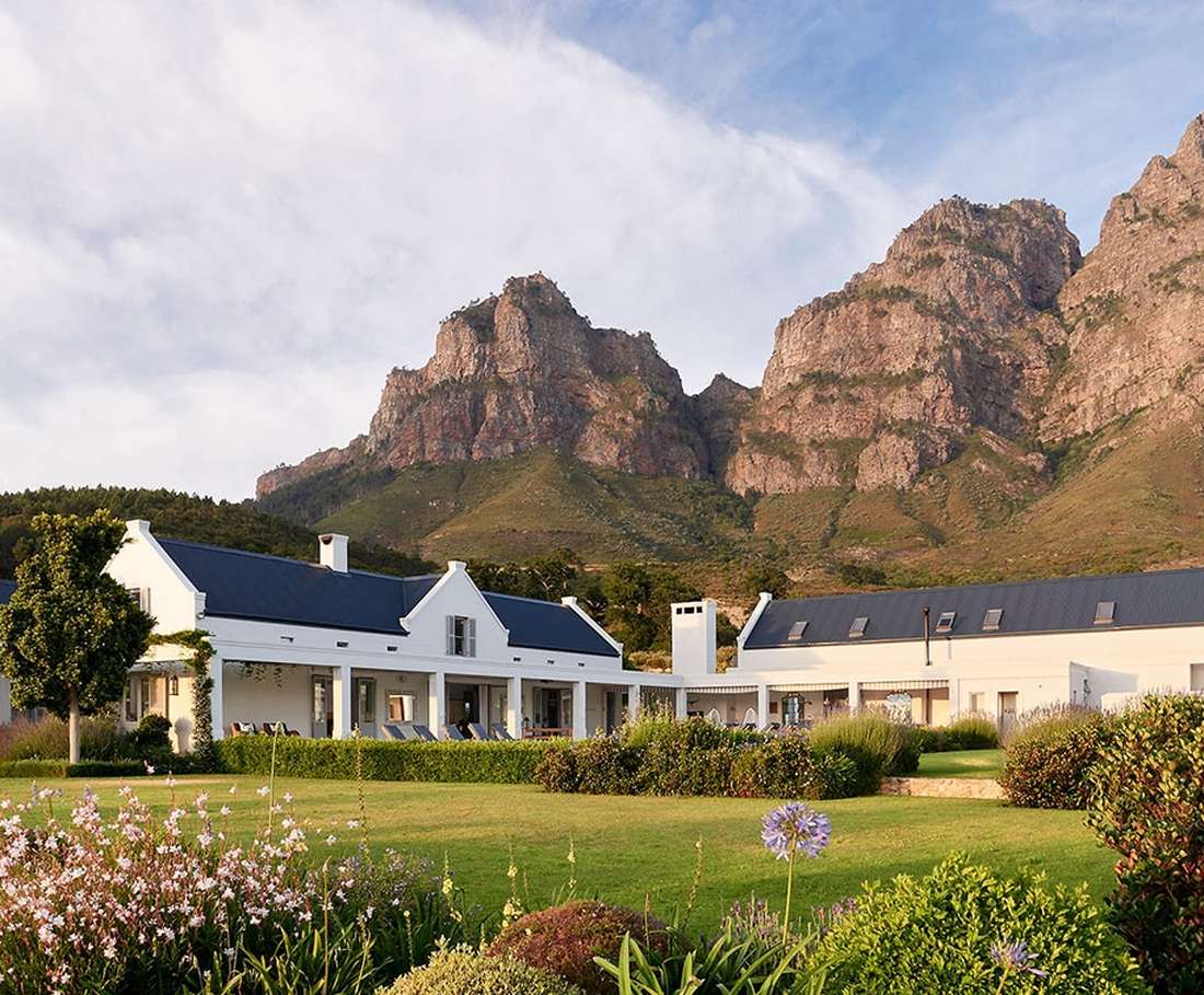 Kaaps-Hollandse huisjes op een wijngoed bij Franschhoek, met de bergen erachter, Zuid-Afrika