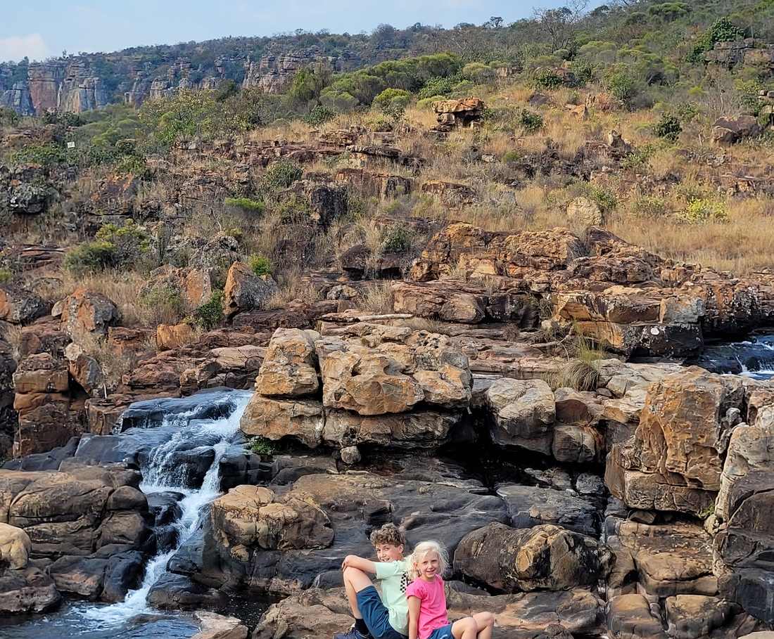 Kinderen bij de watervallen en kolkgaten van Bourke's Luck Potholes, Zuid-Afrika