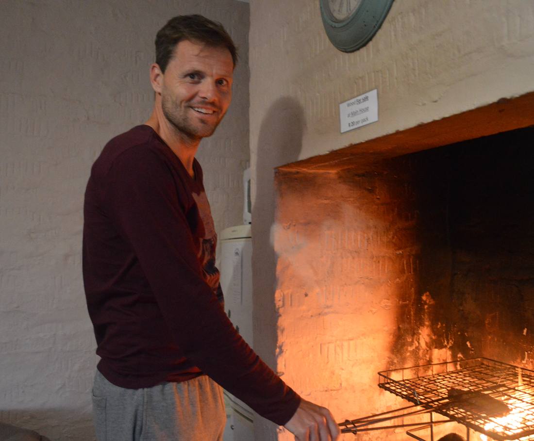 Het vuur in een grote open haard met een braairooster erin, Dullstroom, Zuid-Afrika