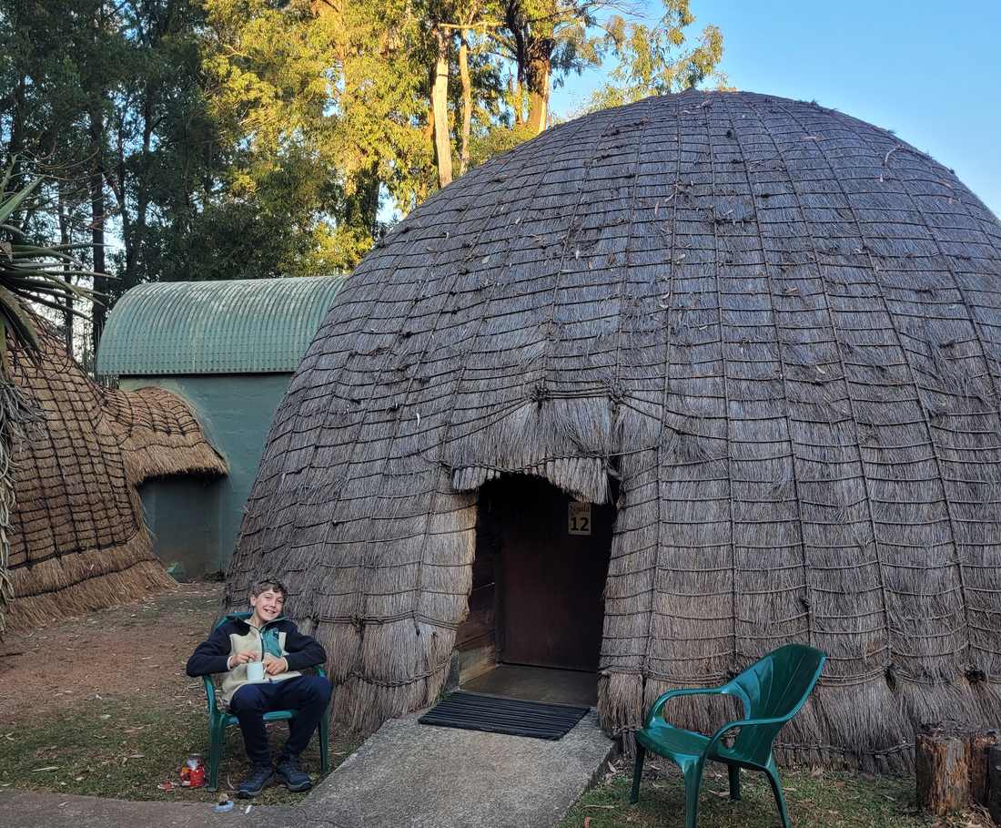 Een ronde rieten hut in traditionele Swazi-stijl in een wildpark in eSwatini