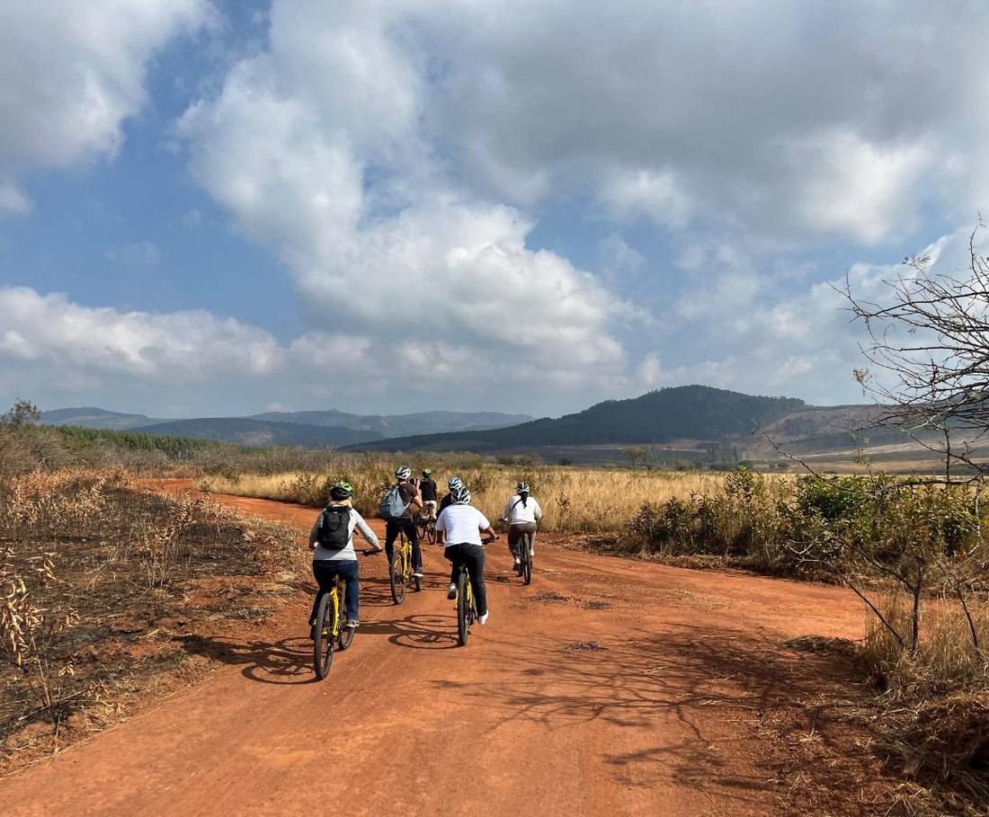Fietsers op een rode zandweg door het natuurgebied in eSwatini