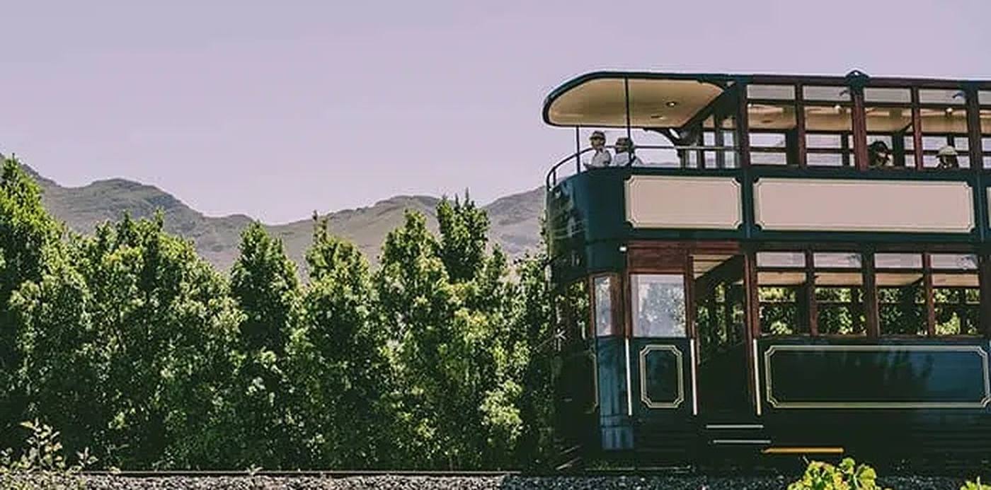 De open wijntram rijdt langs de wijngaarden van Franschhoek, Zuid-Afrika