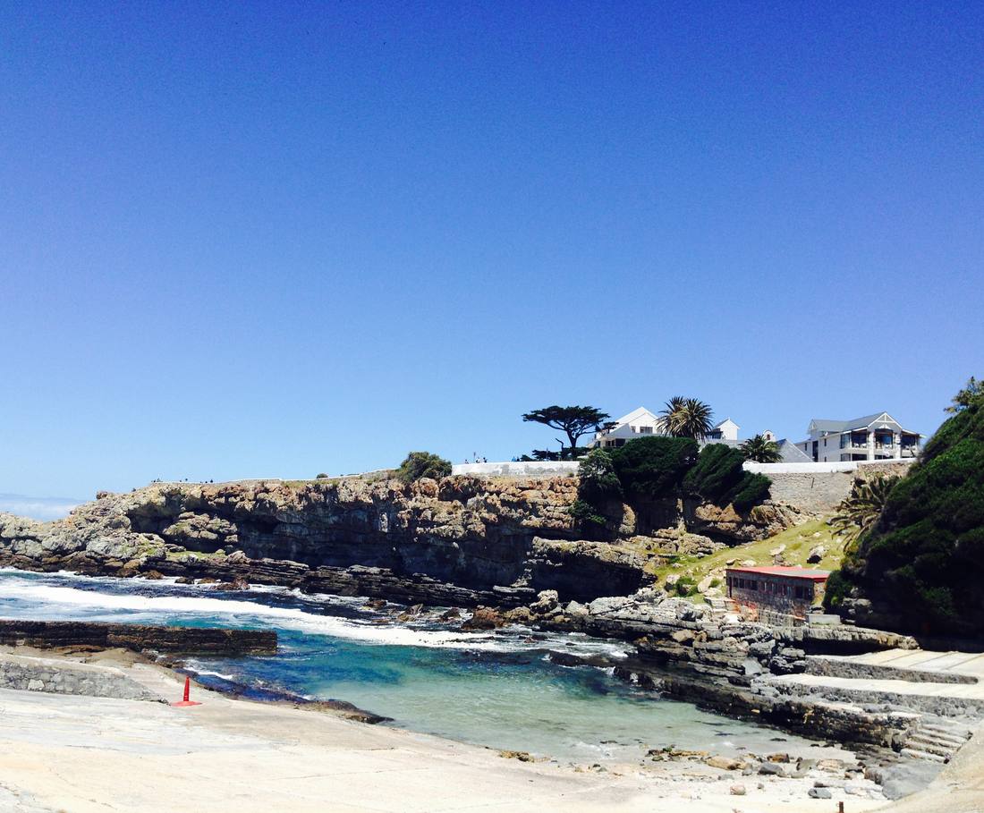 Het rotsbaaitje met helder water langs het Cliff Path in Hermanus, Zuid-Afrika