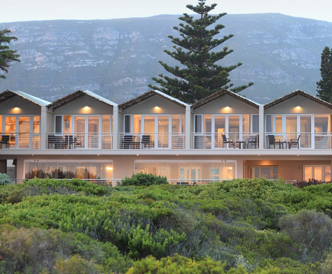De lodge aan de kust bij Hermanus, met de fynbos ervoor en de berg erachter, Zuid-Afrika