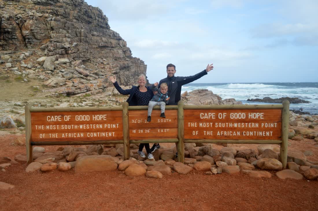 Gezin in de wind bij het bord van Kaap de Goede Hoop, de West-Kaap, Zuid-Afrika
