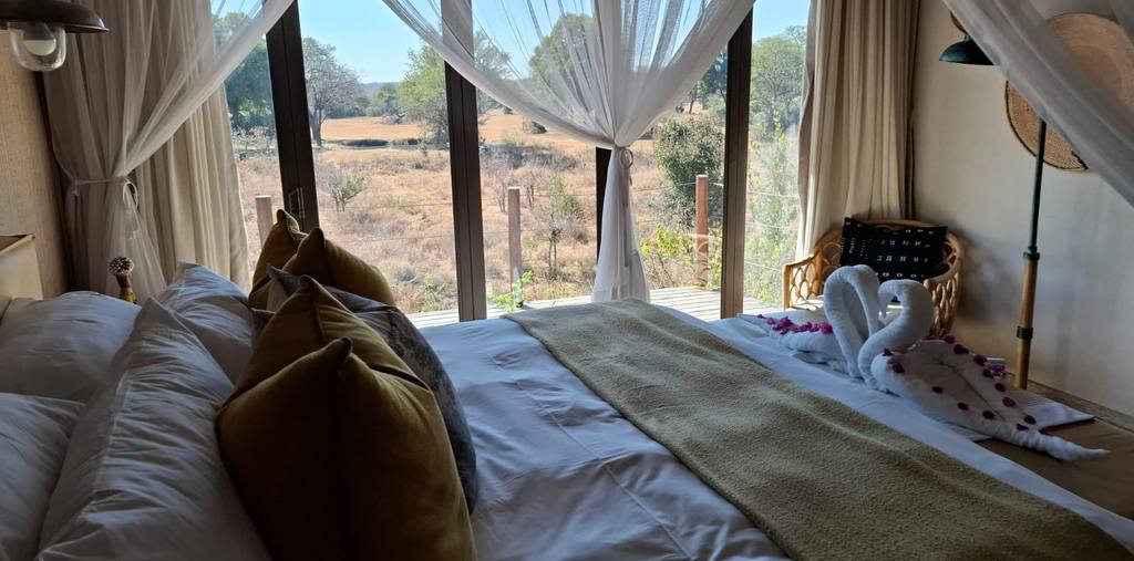 Lodgekamer met klamboe en openslaande deuren naar de bush, Zuid-Afrika