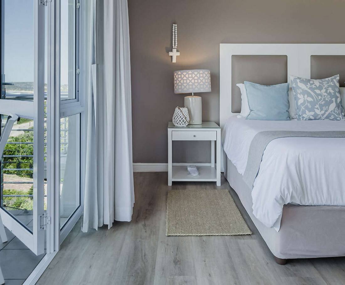 Een kamer met openslaande deuren en uitzicht over de baai bij Plettenberg Bay, Zuid-Afrika
