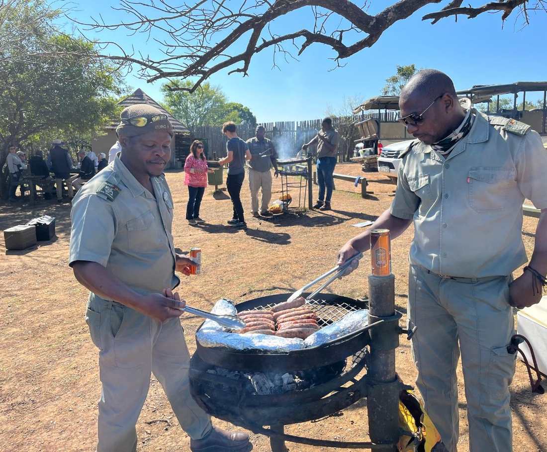 Twee rangers braaien worstjes tijdens een stop op safari, Zuid-Afrika