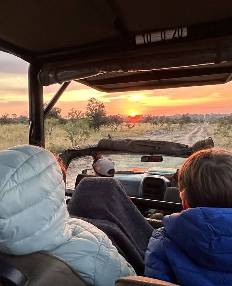 Kinderen in de safarijeep bij zonsopkomst, Zuid-Afrika