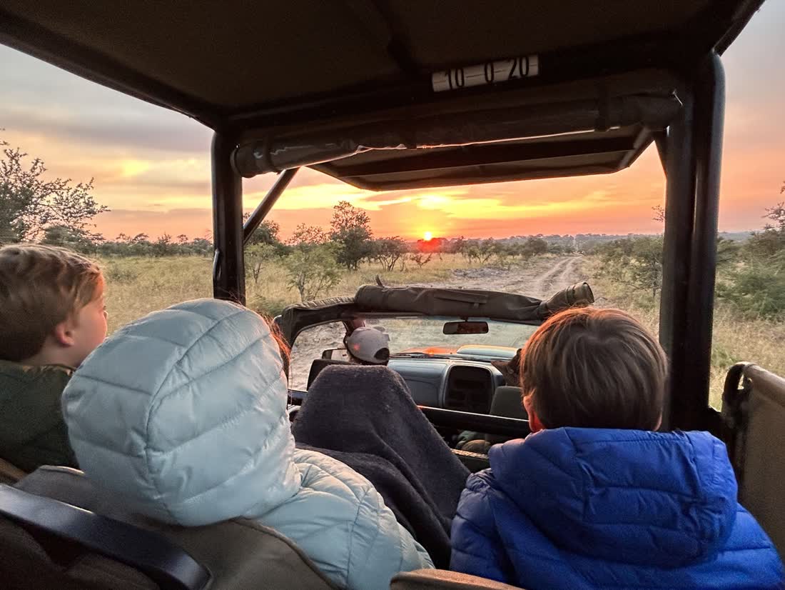 Kinderen in de safarijeep bij zonsopkomst, Zuid-Afrika