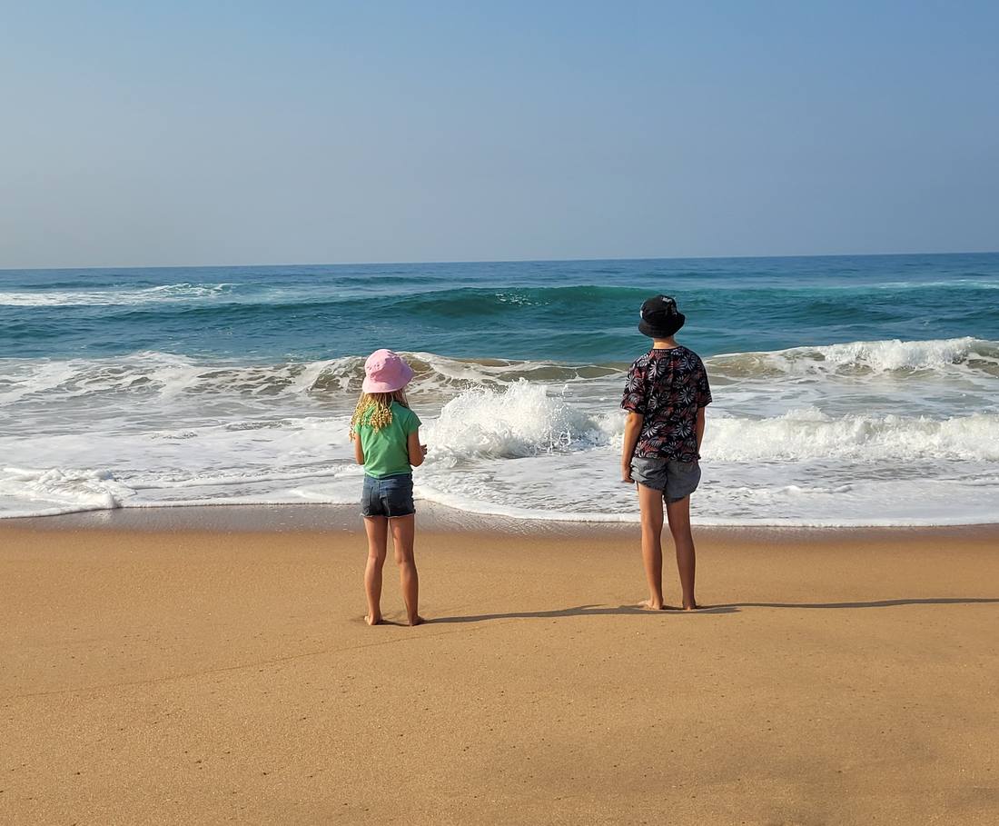 Twee kinderen kijken uit over de branding aan de oostkust bij St. Lucia, Zuid-Afrika