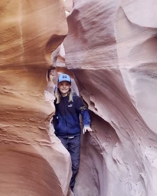 Kind wurmt zich door een smalle slotcanyon in Amerika