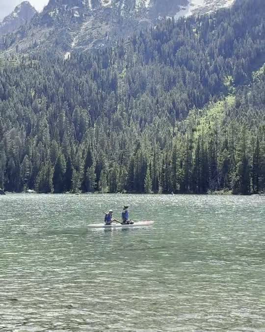Kinderen op een supboard op een bergmeer bij Grand Teton