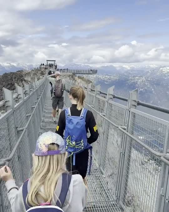 Kinderen lopen over een hangbrug hoog in de bergen in Canada