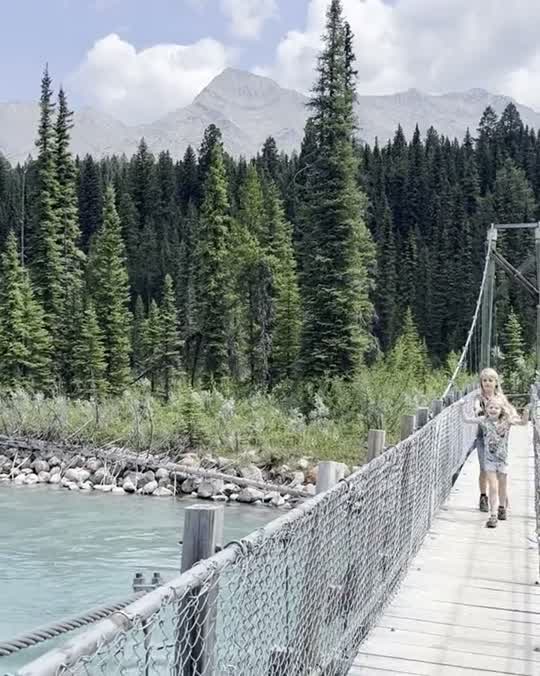 Kind op een hangbrug boven een gletsjerrivier in West-Canada