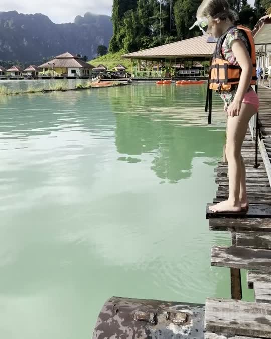 Kind springt van een drijvend huisje het meer van Khao Sok in tijdens een familiereis door Thailand
