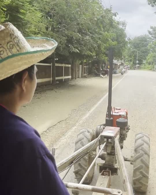 Achter op een boerentractor door een dorp in centraal Thailand, in de buurt van Sukhothai